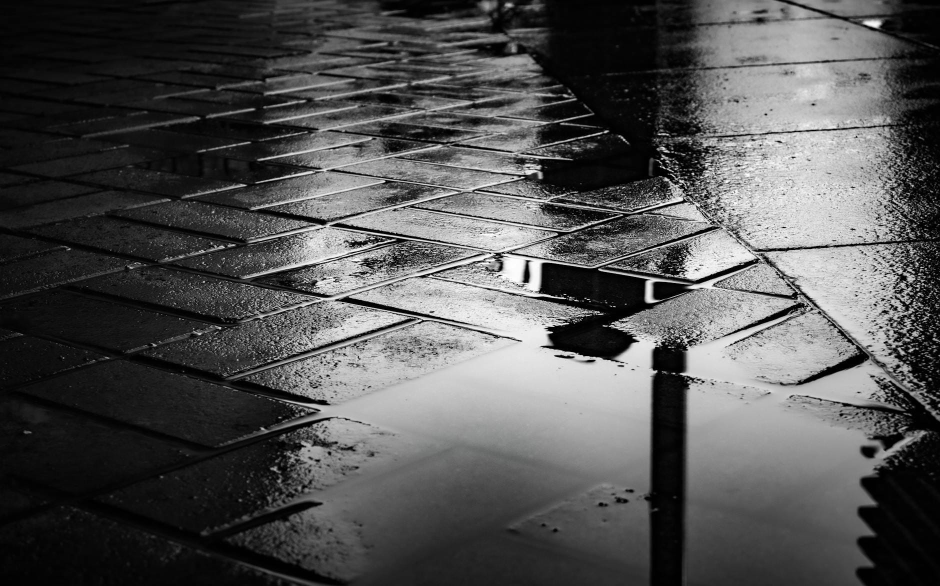 Mokra nawierzchnia tarasu z kałużami odbijającymi światło