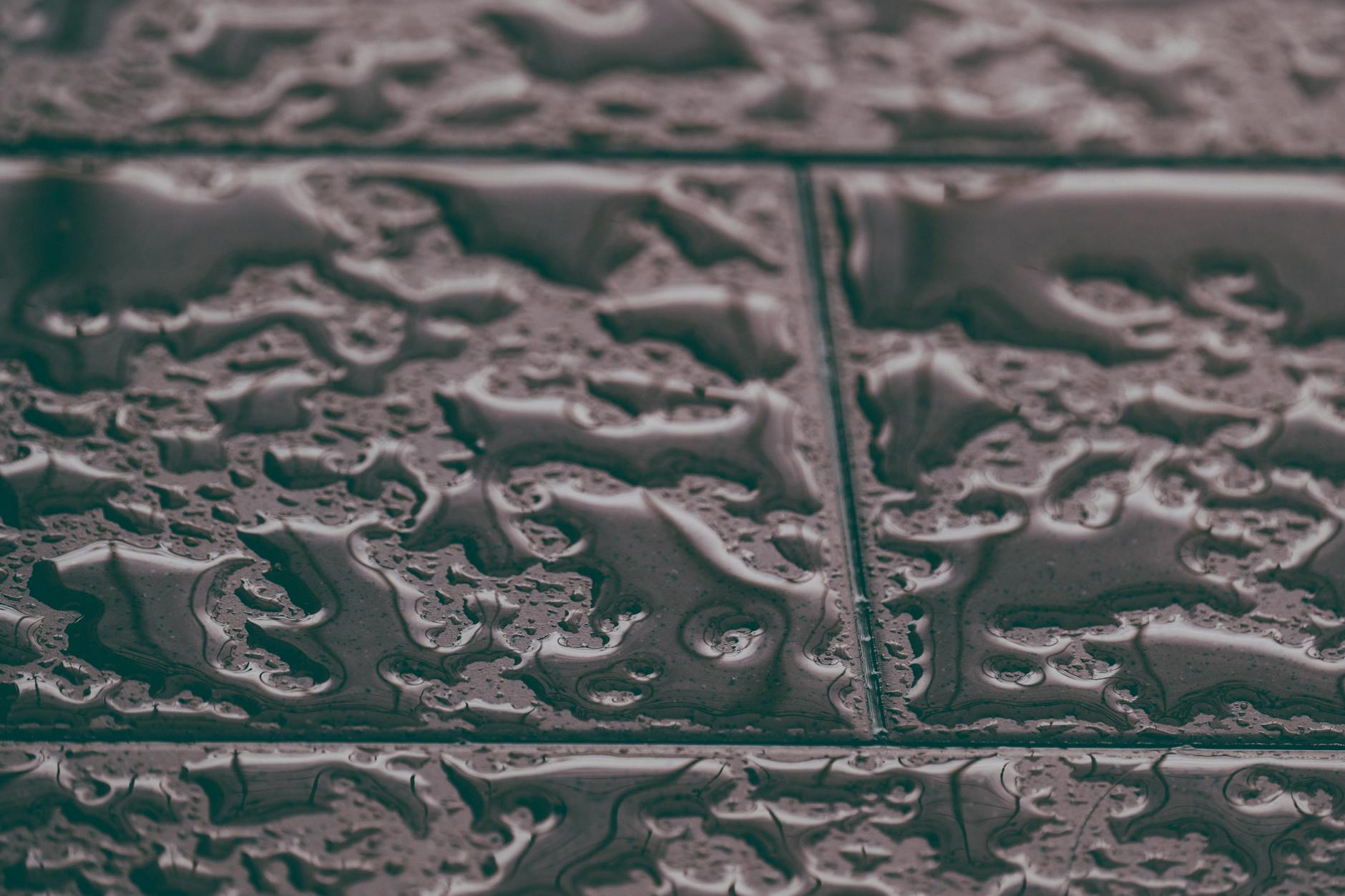 Zbliżenie mokrych płyt gresowych z widoczną teksturą antypoślizgową