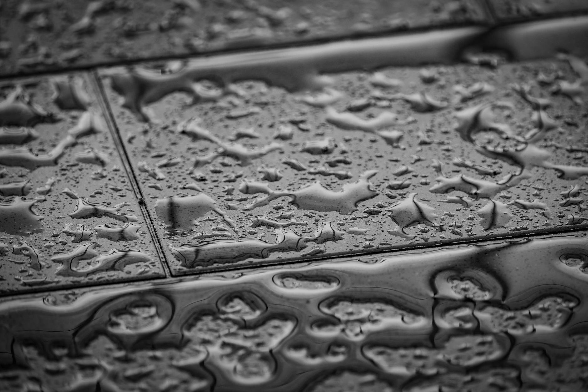 Zbliżenie mokrych płytek gresowych z kroplami wody na powierzchni