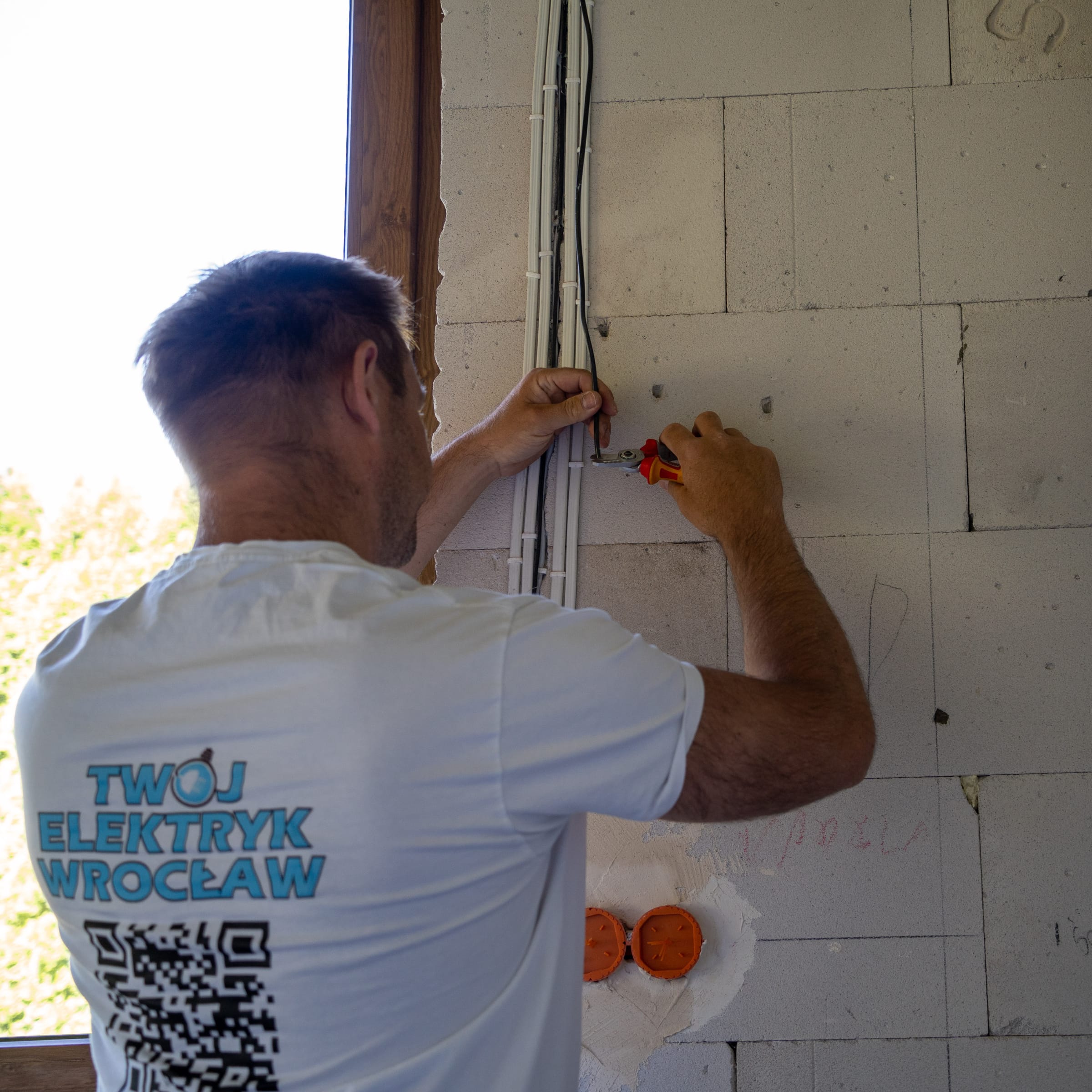 elektryk układa przewody instalacji elektrycznej