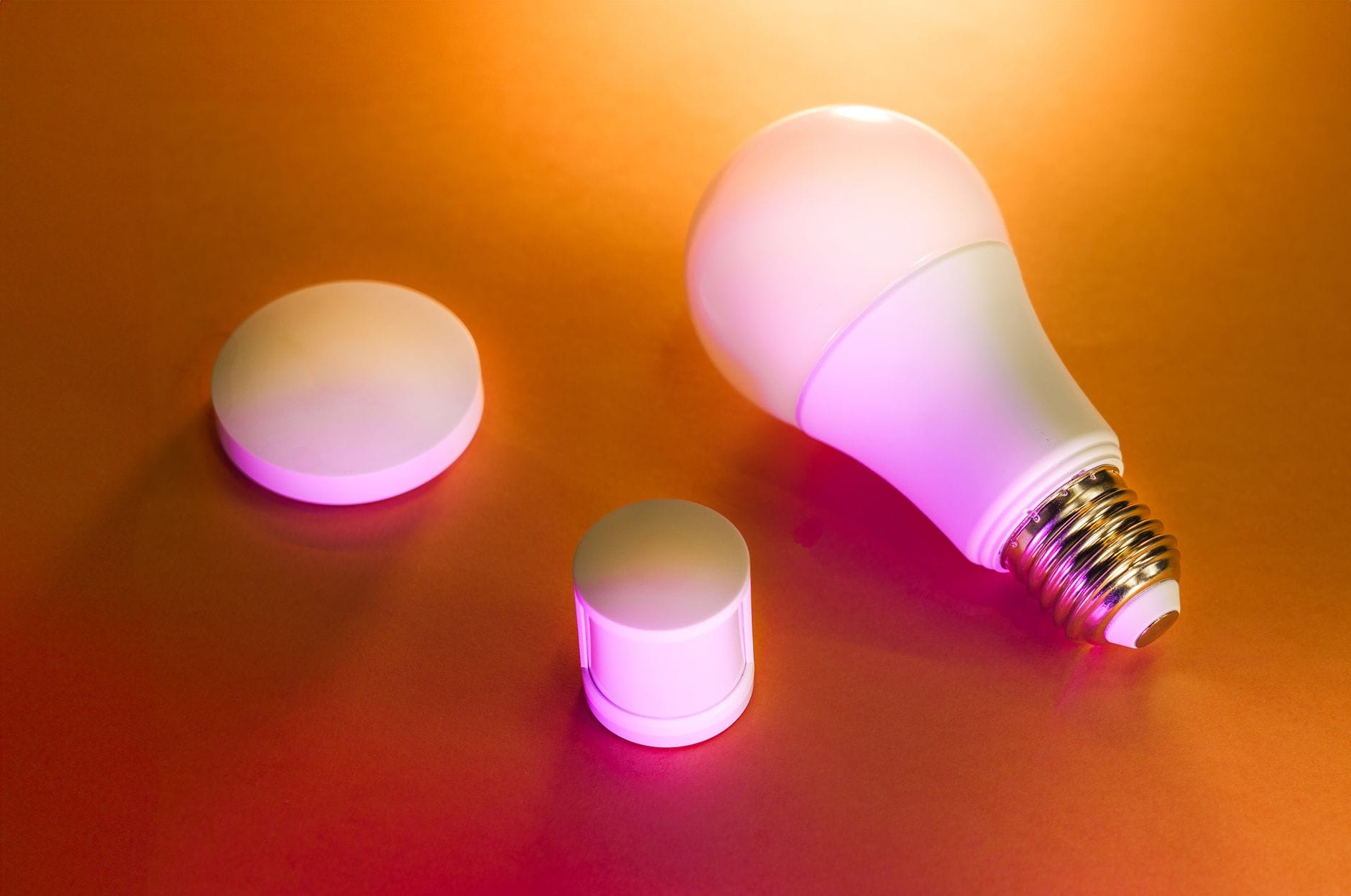Inteligentna żarówka LED z akcesoriami na pomarańczowym tle